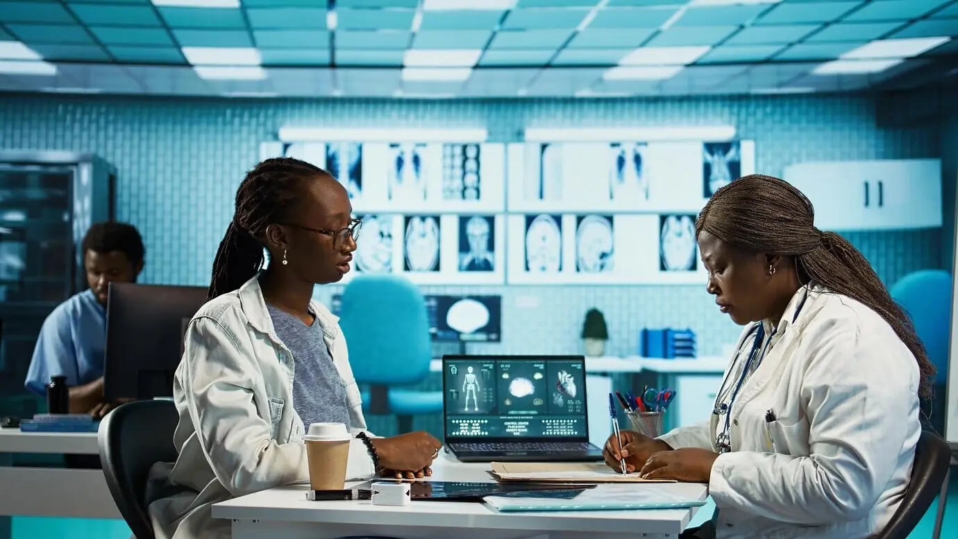 Врач общей практики выписывает антибиотики и витамины на страховом бланке.